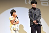 大西利空（左）を見守る松田龍平（右）。