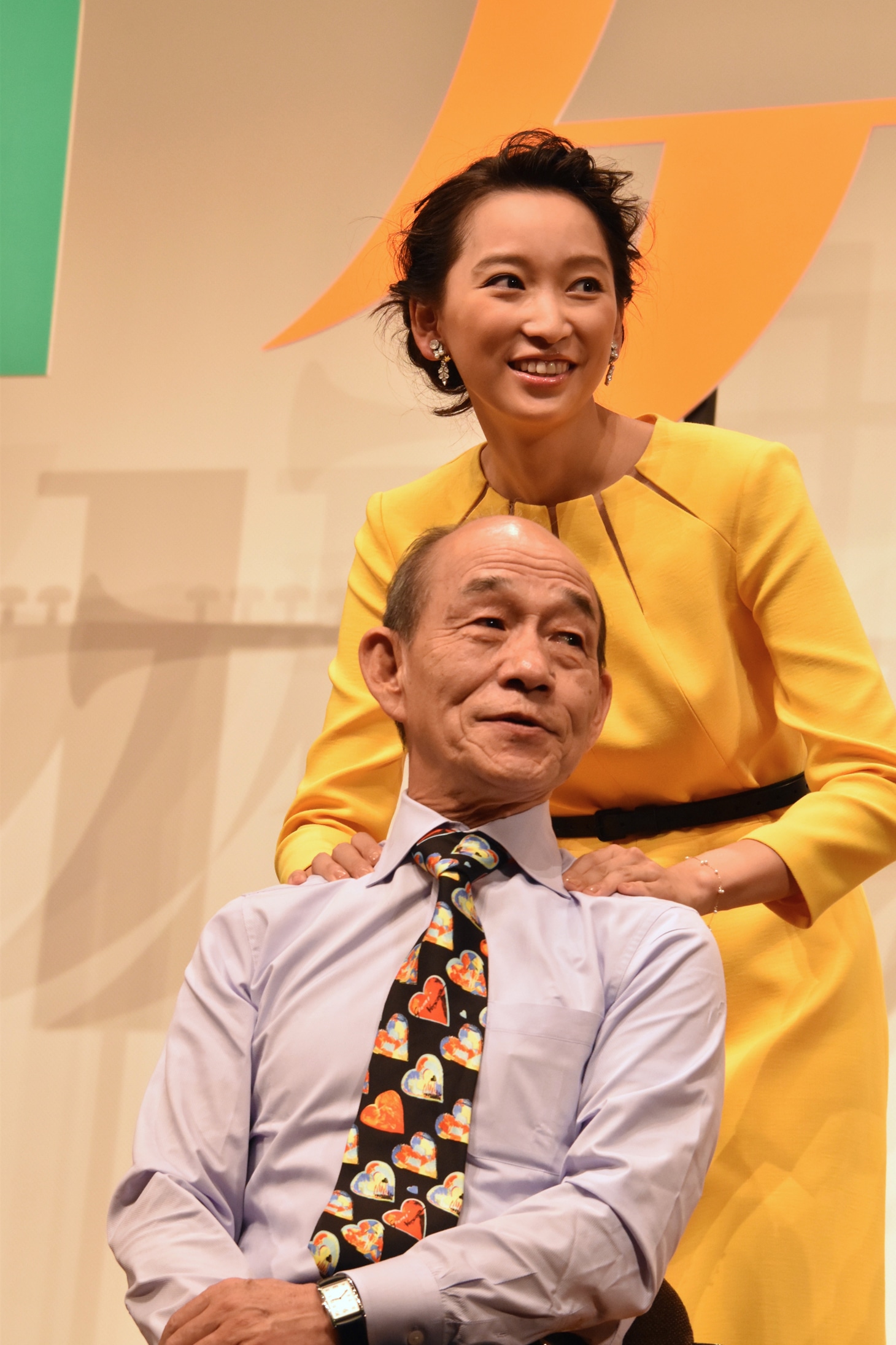 笹野高史（前）の肩を揉む杏（後）。