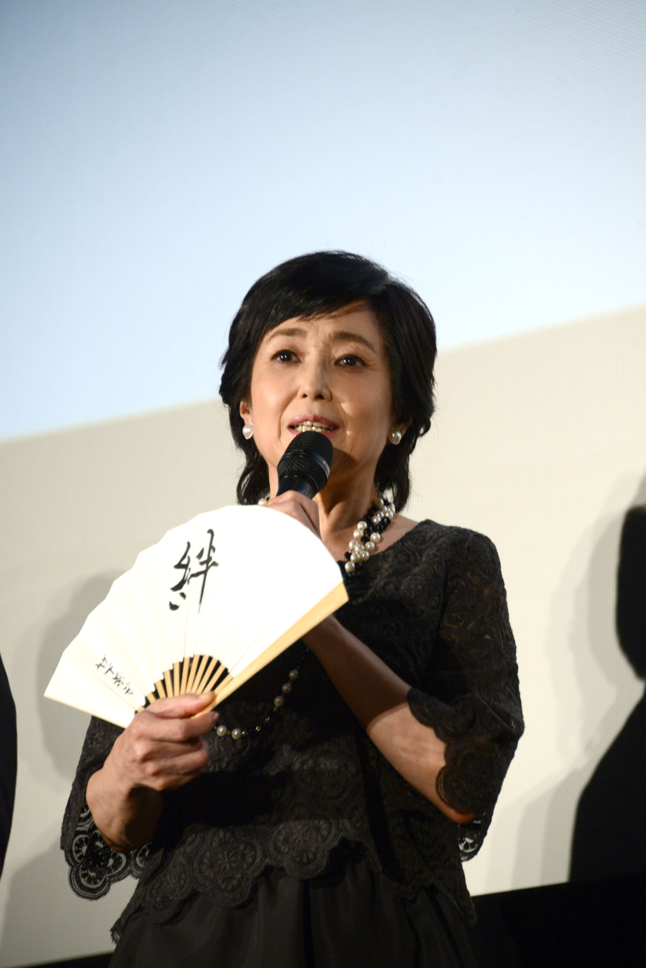 座右の銘を記した扇子を見せる竹下景子。