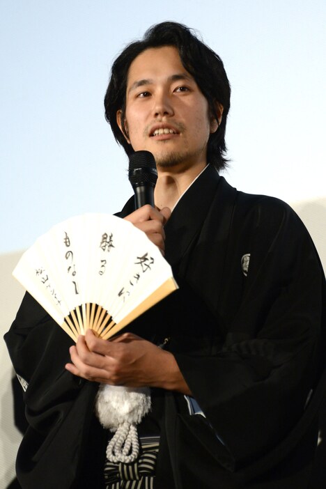 座右の銘を記した扇子を見せる松山ケンイチ。