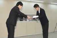 「何者」特別宣伝隊長に任命された早稲田大学3年生・齊藤弘樹さん（左）に任命証を渡す佐藤健（右）。