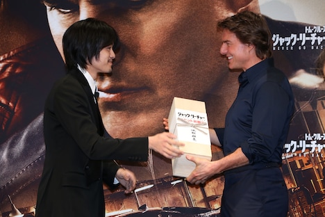池松壮亮（左）からプレゼントの日本酒を受け取るトム・クルーズ（右）。