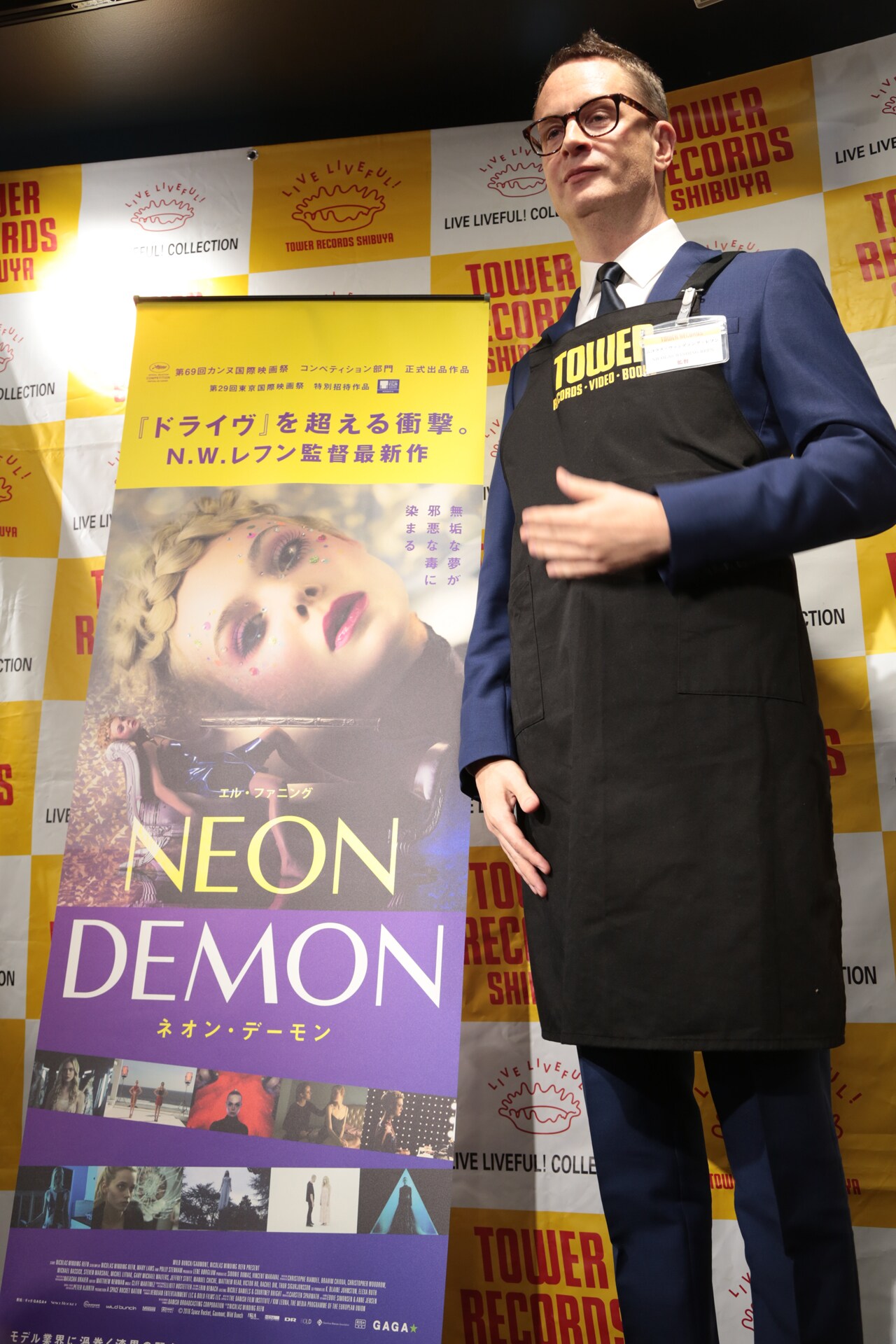 タワーレコード店員のエプロンを着用したニコラス・ウィンディング・レフン。