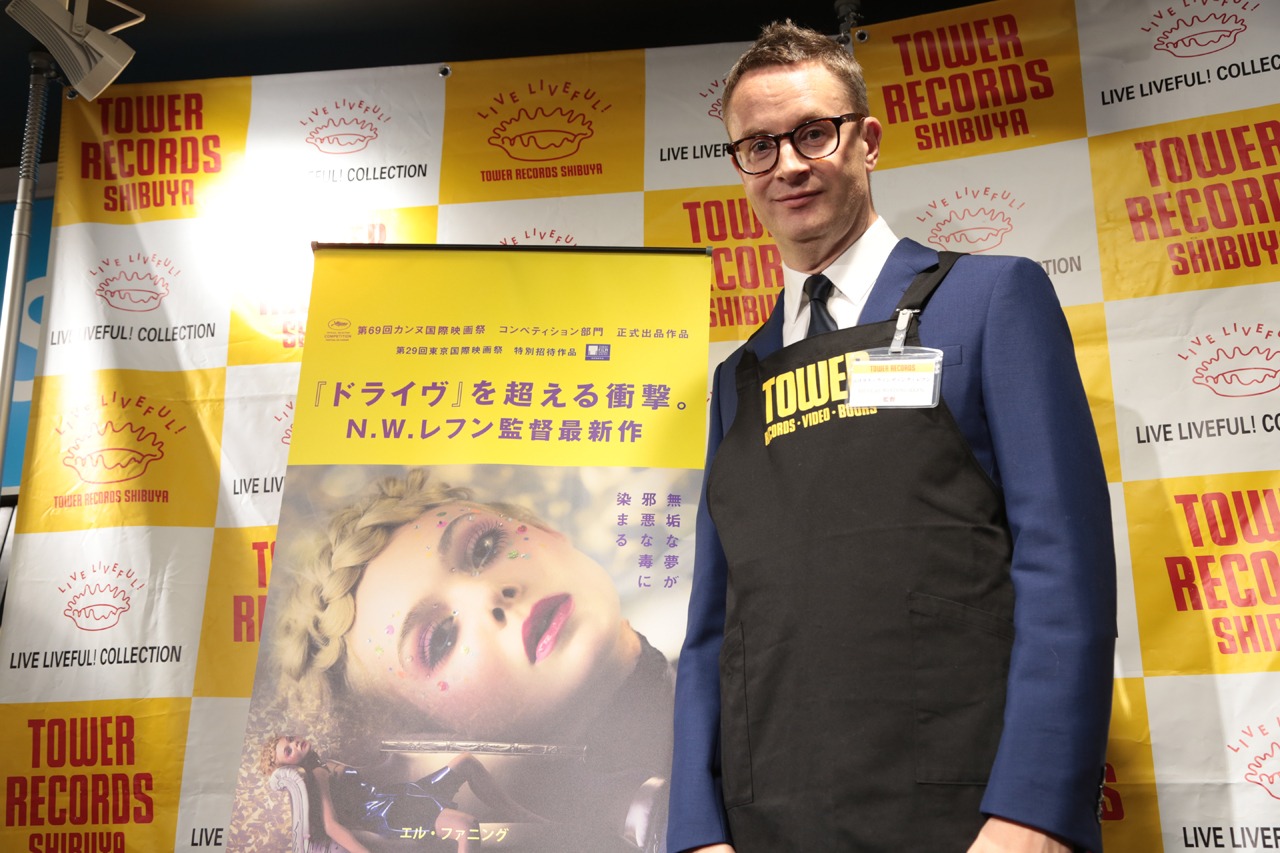 タワーレコード店員のエプロンを着用したニコラス・ウィンディング・レフン。