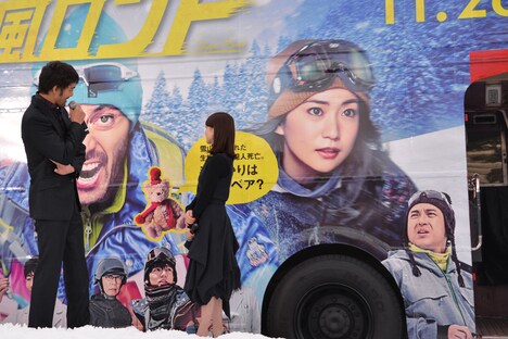 自身の顔が大きく施されたバスを見て照れる阿部寛（左）。