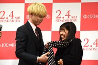 ファンにマフラーを巻く坂口健太郎（左）。