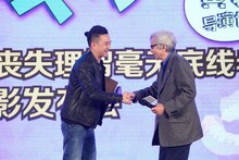 満面の笑みでホアン・レイ（左）と握手する山田洋次（右）。