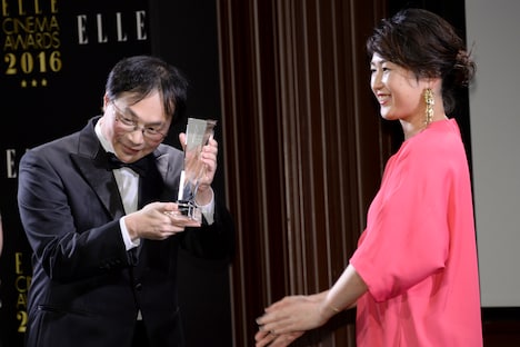 トロフィーを受け取る深田晃司(左)。