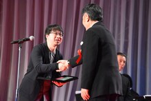 原田眞人（右）と握手する新海誠（左）。