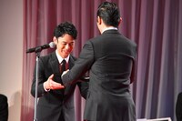 本木雅弘（右）から盾を受け取った妻夫木聡（左）。