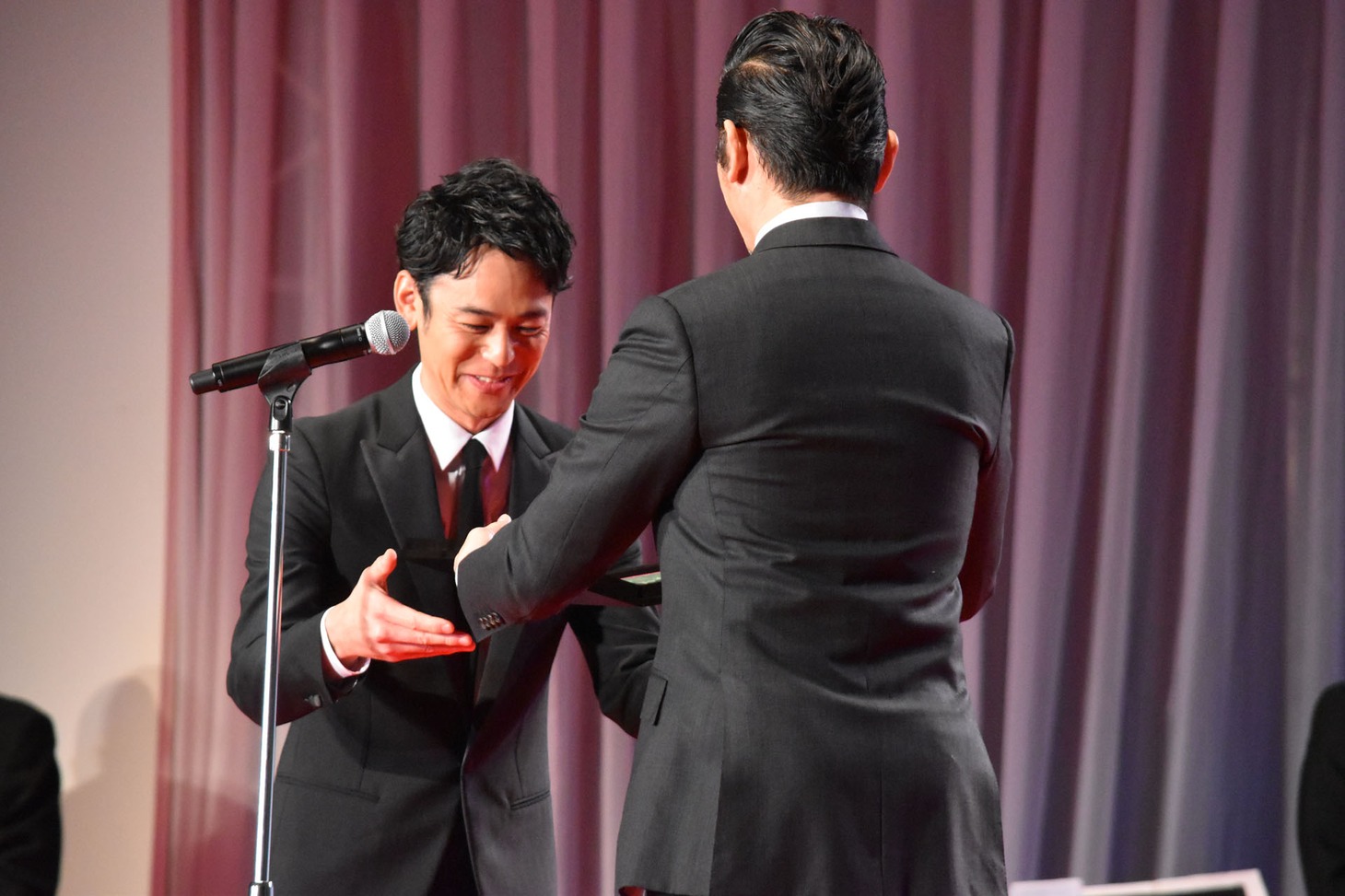 本木雅弘（右）から盾を受け取った妻夫木聡（左）。