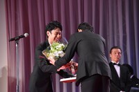 李相日（右）から花束を受け取った妻夫木聡（左）。