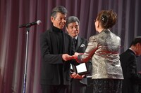 石原まき子（右）から賞金300万円を受け取った柴田恭兵（左）。