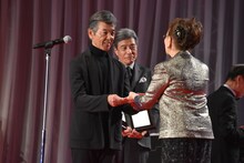 石原まき子（右）から賞金300万円を受け取った柴田恭兵（左）。