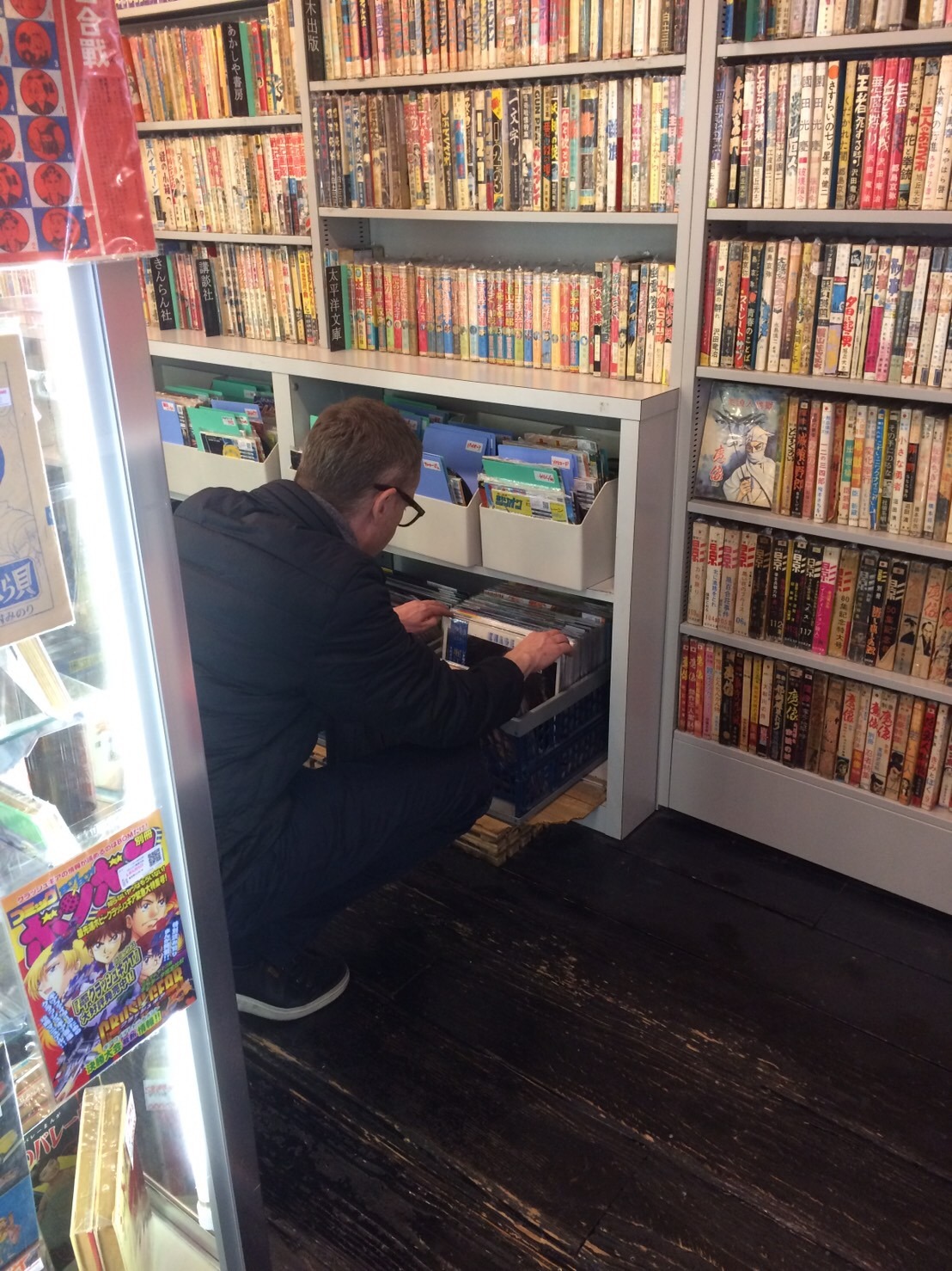 まんだらけで棚を物色するニコラス・ウィンディング・レフン。