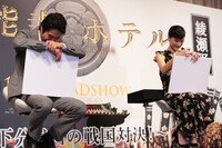 綾瀬はるか（右）の絵を盗み見て笑う堤真一（左）。