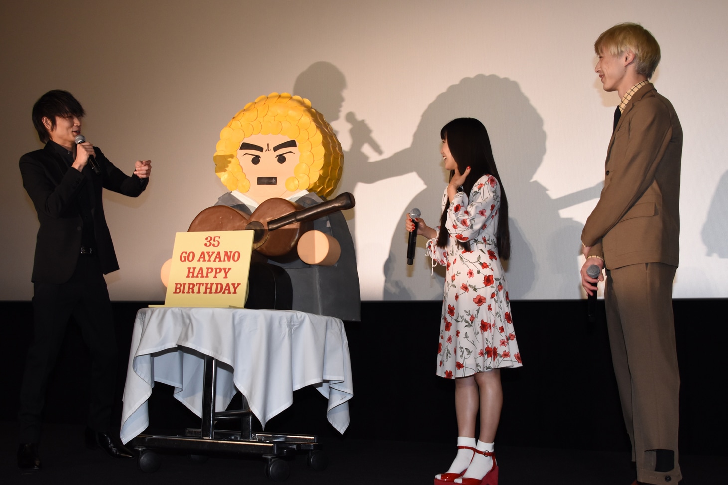 ケーキを挟んでにこやかに会話する登壇者たち。