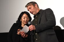 当選者の席番号を日本語で読むために、通訳に発音を尋ねるマッツ・ミケルセン。