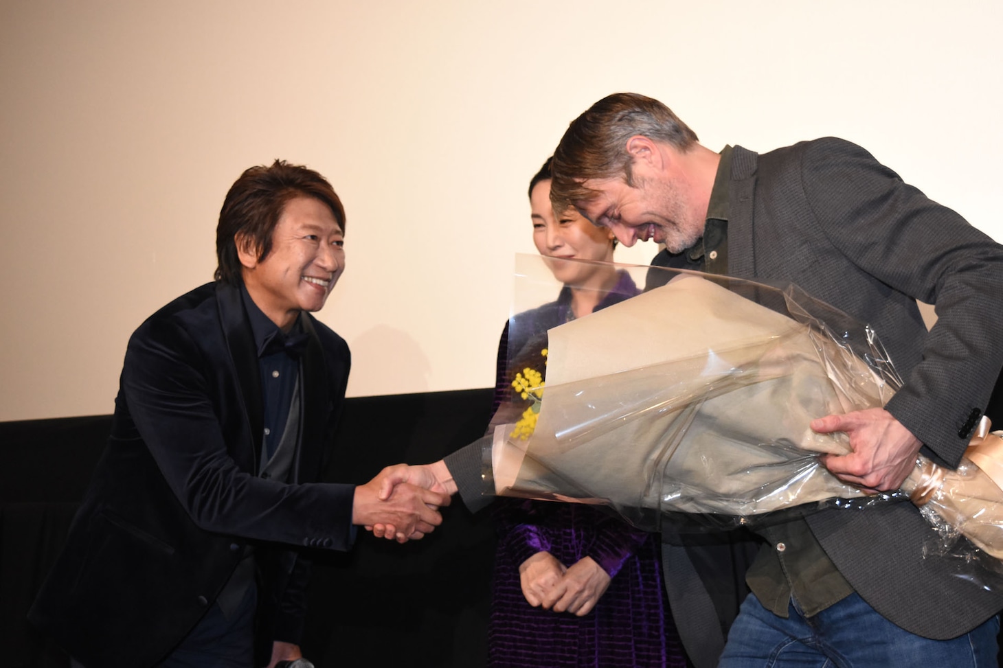 井上和彦（左）と握手するマッツ・ミケルセン（右）。