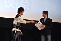 司会のマイクに不具合が起きたのに気付き、自らのマイクを差し出す山崎賢人（左）。