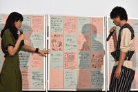 ファンの手書きメッセージを読む川口春奈（左）と山崎賢人（右）。