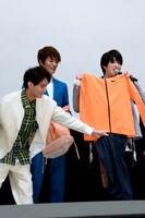 トレーニングウェアを体に当てる西銘駿（右）と、手伝う磯村勇斗（左）。