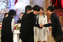 握手を交わす野田洋次郎（中央）と山口一郎（右）。