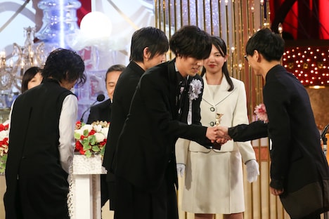 握手を交わす野田洋次郎(中央)と山口一郎(右)。