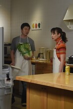 すき焼き用の材料を冷蔵庫から取り出す新井浩文（左）。