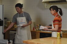 すき焼き用の材料を冷蔵庫から取り出す新井浩文（左）。