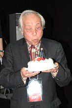 ケーキのろうそくを吹き消す内藤誠。