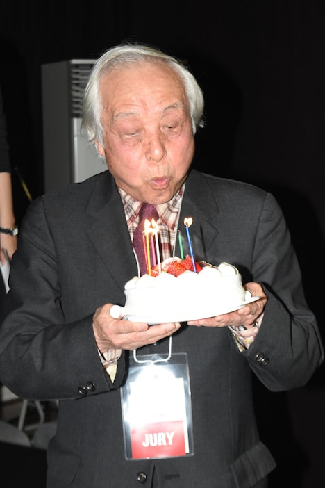 ケーキのろうそくを吹き消す内藤誠。