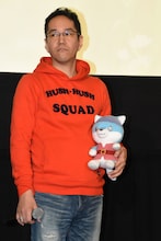 劇中キャラクター、ジョイのぬいぐるみを抱える神山健治。