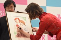 「PとJK」複製原画にサインする玉城ティナ。