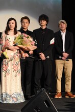 歌唱中のDream Amiを見つめるキャストと監督の新城毅彦。