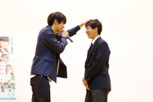 「ちょっと想像していたのと違いますが……（笑）」と言いながら男子生徒の頭を撫でる中川大志（左）。