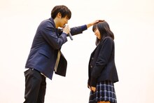 女子生徒の頭を撫でる中川大志（左）。