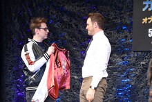 ジェームズ・ガン（左）にスカジャンを着せてくれるよう頼むクリス・プラット（右）。