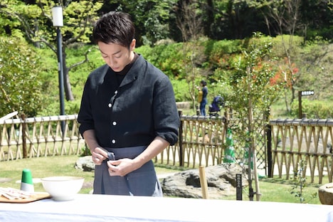 エプロンを着ける佐藤健。