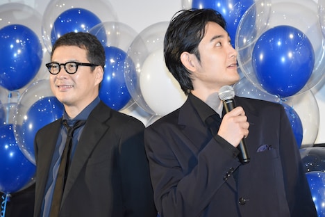 田中哲司（左）と、映画のタイトルをど忘れしてスクリーンを確認する松田龍平（右）。