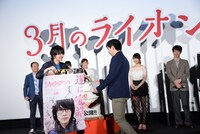 抽選で当たった観客にサイン入りポスターを贈呈する神木隆之介（左）。