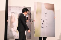 上戸彩が「さいとうたくみ」と平仮名で書いたニセのサインを紹介するパネル。