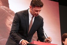 手形に名前を入れるヒュー・ジャックマン。