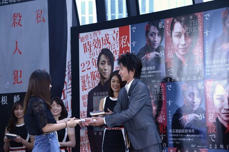 ファンにサイン本を手渡す藤原竜也（右）。