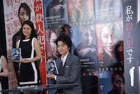 サインした本をカメラに向ける藤原竜也。