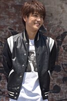 革ジャンで笑顔を浮かべる、発表会冒頭の岩田剛典。