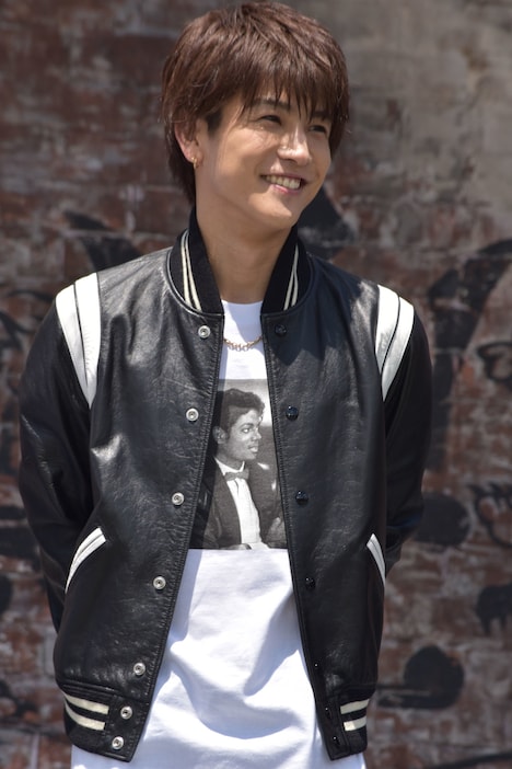 革ジャンで笑顔を浮かべる、発表会冒頭の岩田剛典。