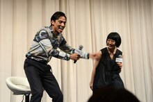 園子温がバケツから血糊を撒く様子を再現する満島真之介（左）。