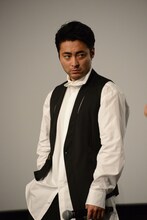 登壇者たちの目を盗み、ポケットから小道具を取り出そうとする山田孝之。