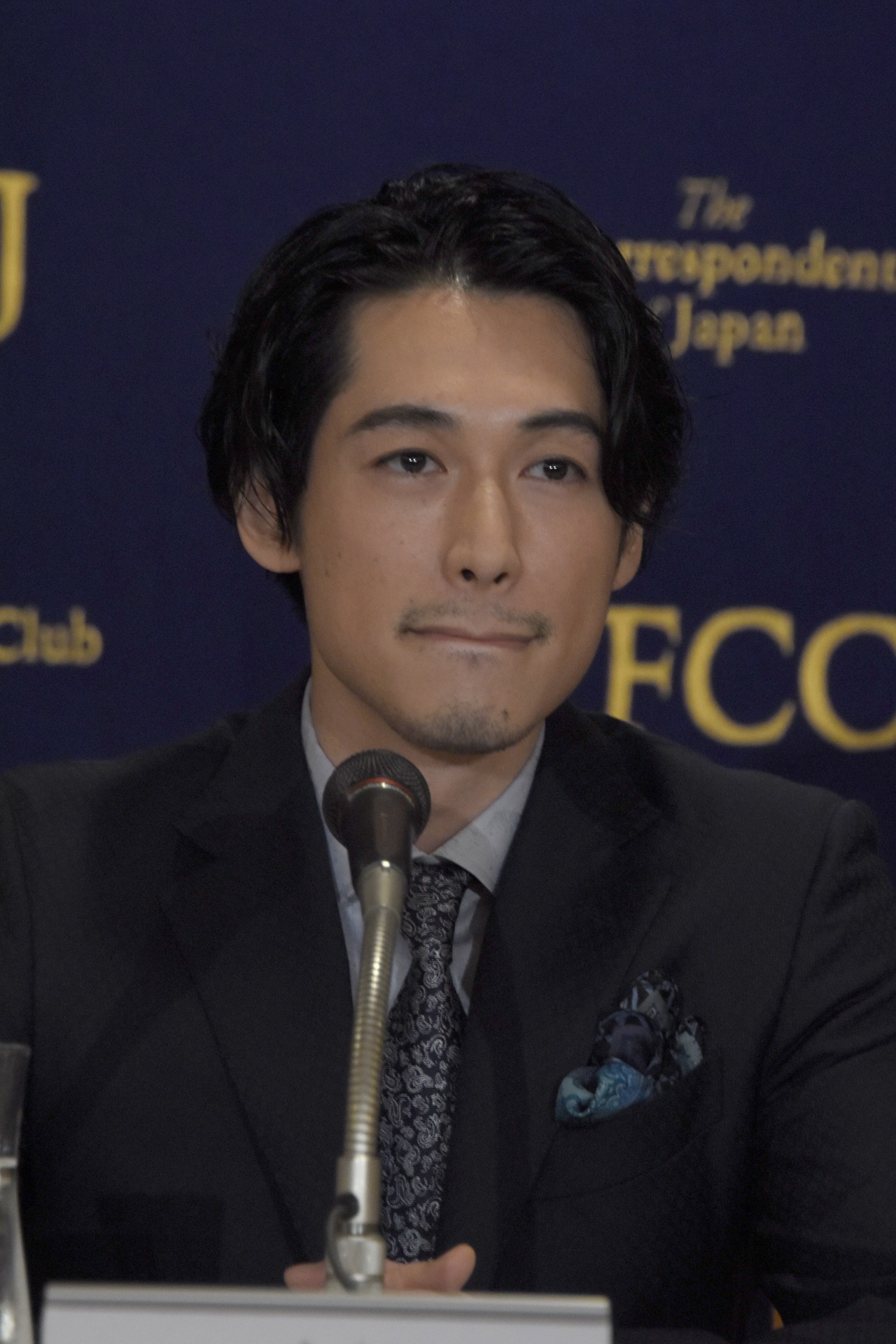 真剣な表情で質問を聞くディーン・フジオカ。